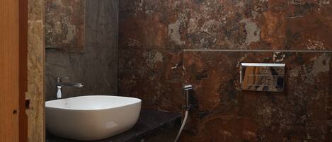 A bathroom with a sink, toilet, and a hand dryer mounted on the wall.