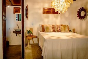 A bedroom with a bed, bedside tables, a hanging light fixture, a mirror, and a wall-mounted shelf. - Cabaré du Vento (Cruz)