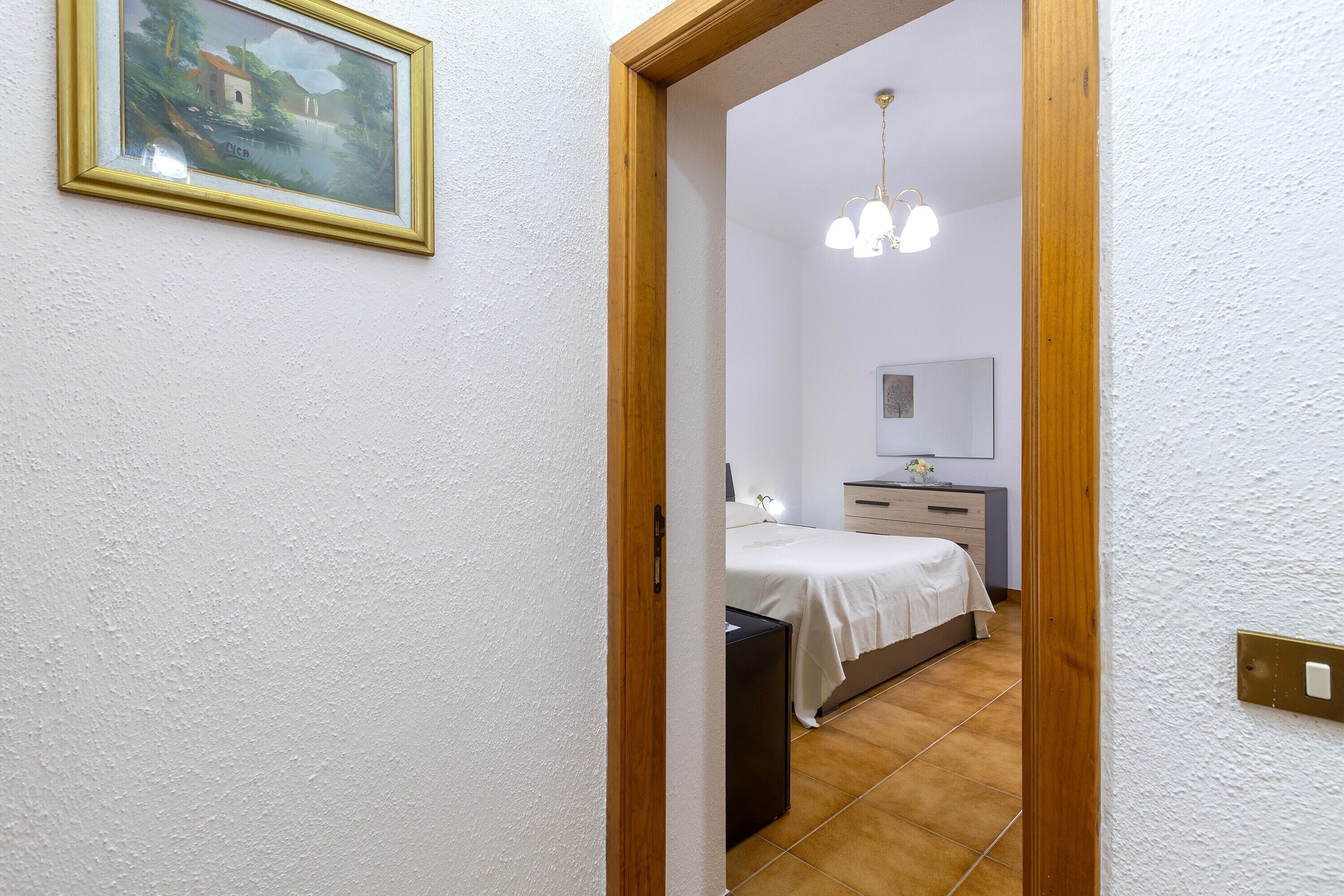 Une chambre à coucher avec un lit, une table de chevet et une commode.