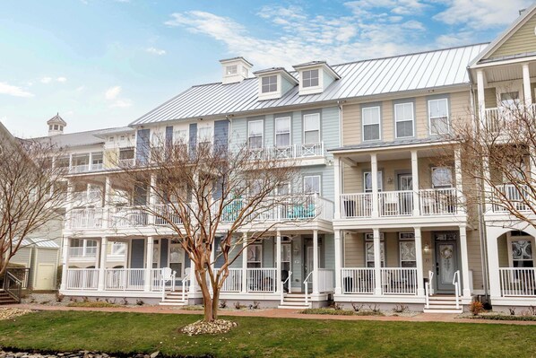 A multi-story residential building with a porch, balconies, and a small tower. - Sunset Island - 5 Brs/ Sleeps 12 / 2 pools (Ocean City)
