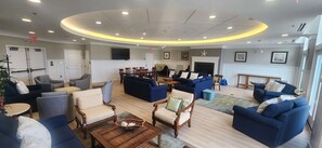 A spacious lounge area with multiple seating options, including sofas and armchairs, a television, and a fireplace. - Sunset Island - 5 Brs/ Sleeps 12 / 2 pools (Ocean City)
