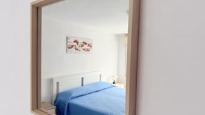 Een slaapkamer met een bed, een nachtkastje en een wanddecoratie.