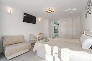 A modern bedroom with a bed, a sofa, a desk, and a wardrobe. - Olympia 4 - Studio including wifi and dishwasher (Costa Adeje)