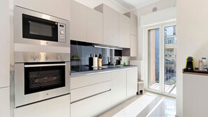 Una cucina moderna con elettrodomestici integrati, un'ampia finestra e vista sulla città.