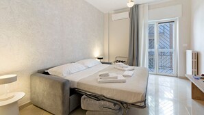 Una moderna camera d'albergo con un letto, un comodino e vista all'esterno.