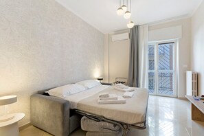 A modern hotel room with a bed, bedside table, and a view of the outside. - Abbrescia 10 – Central Bari Apartment with Balcony, Self Check-in, Wi-Fi, Sleeps 6 (Bari)