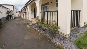 A row of white buildings with arched doorways and a paved walkway. - Stag Lodge (Chorley)