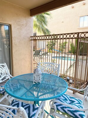 A round table with a white metal frame and blue patterned cushions, a white metal chair, and a decorative lantern on the table. - Cute 1 Bed  in the heart of Fountain Hills (Fountain Hills)