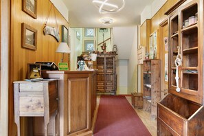 A wooden interior with a desk, a red carpet, and a bookshelf. - 'Triple Room 3' with Shared Terrace in Bionaz (Dzovennoz)