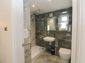 Un bagno moderno con box doccia in vetro, lavandino e water.