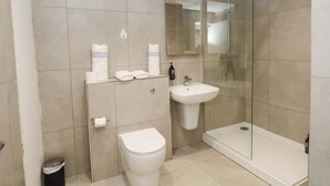 Ein modernes Badezimmer mit Toilette, Waschbecken und einer Duschkabine.