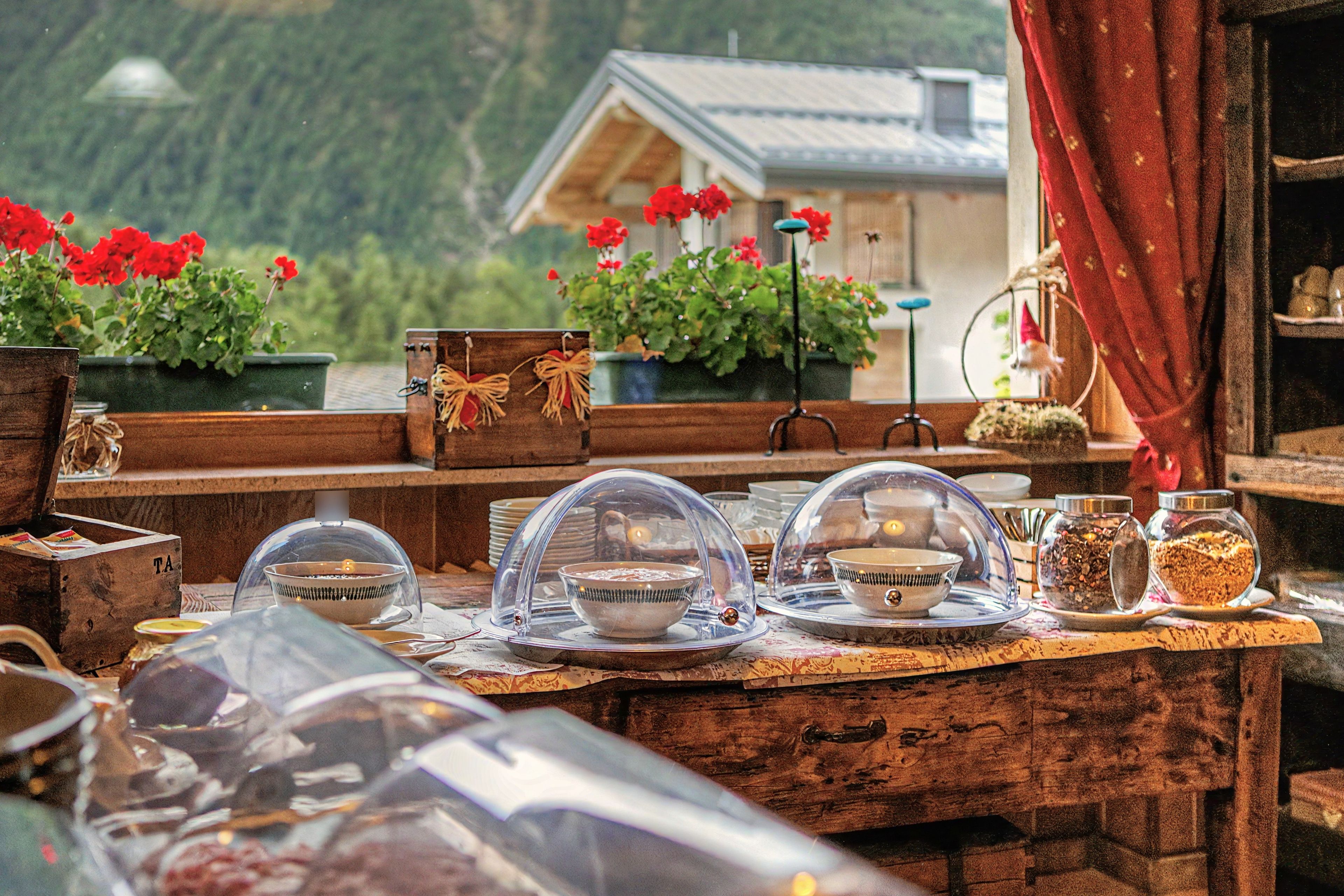 A rustic wooden table with a variety of items including bowls, a cash register, and a cash box.