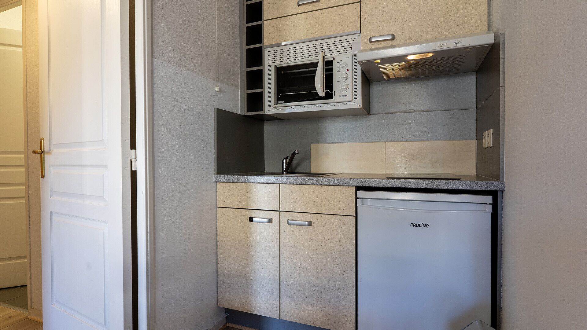Una cocina compacta con horno empotrado, lavavajillas y una pequeña encimera.