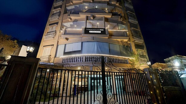 A multi-story building with balconies and a sign that reads "Townhouse Oak." - Super Deluxe Room Hotel Mayvilas (Dehradun)