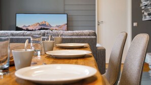A dining table set with plates, glasses, and a remote control. - Rukatunturintie 8 g2 by Interhome (Kuusamo)