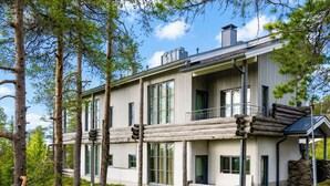 A modern log cabin with large windows, a balcony, and a stone staircase. - Rukatunturintie 8 g2 by Interhome (Kuusamo)