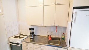 Une cuisine équipée d’une cuisinière, d’un four, d’une machine à café, d’un évier et d’un réfrigérateur.