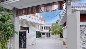 A courtyard with a gated entrance, a covered walkway, and a building with a tiled roof. - Classic With Balcony Daulatabad Fort Aurangabad (Chhatrapati Sambhajinagar)