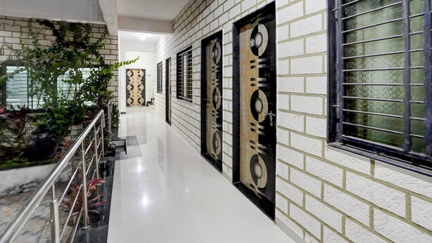 A corridor with white brick walls, black and beige decorative panels, and a metal railing. - Classic With Balcony Daulatabad Fort Aurangabad (Chhatrapati Sambhajinagar)
