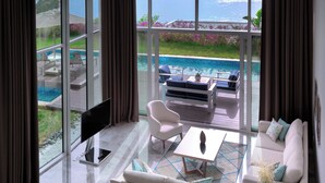 A modern living room with a large window overlooking a pool and garden. - Vitalica Wellness Bodrum (Bogazıcı)
