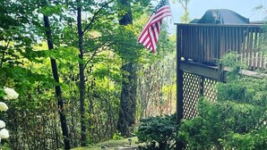 A garden pathway with a wooden deck and an American flag. - Cardinals Nest In The Smokies ~ Family Friendly (Haywood County)
