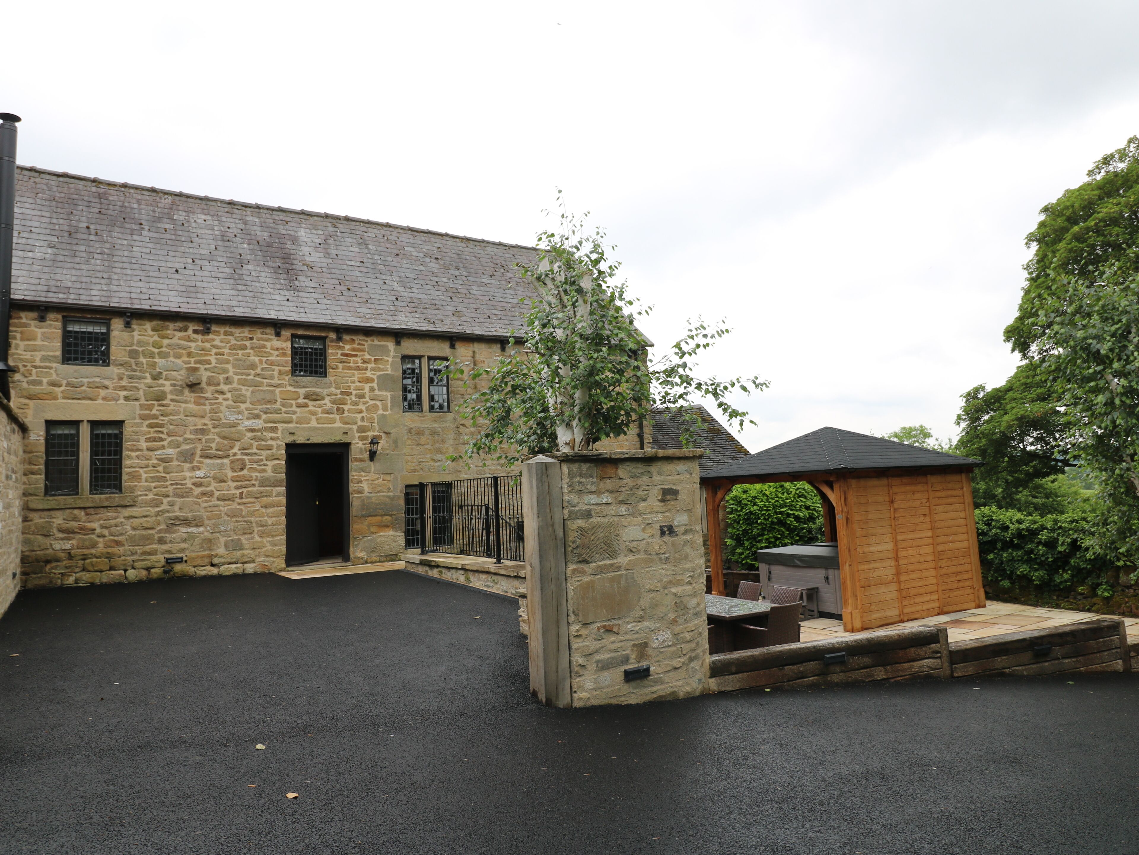 A stone building with a wooden structure in the foreground.