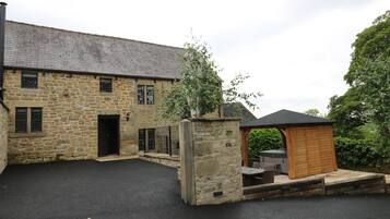 A stone building with a wooden structure in the foreground.