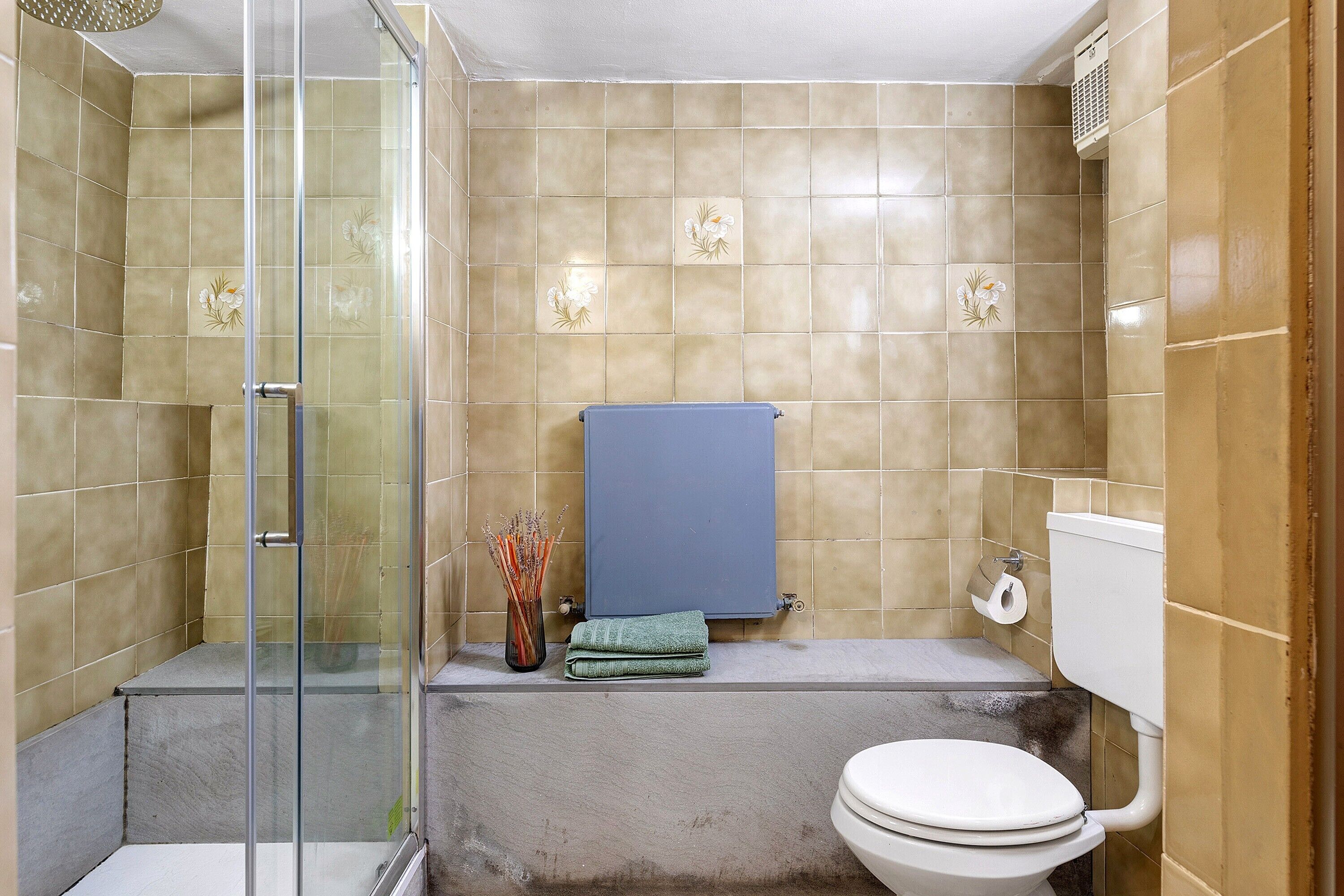 Ein Badezimmer mit Duschkabine, Toilette und Badewanne.