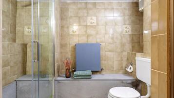Ein Badezimmer mit Duschkabine, Toilette und Badewanne.