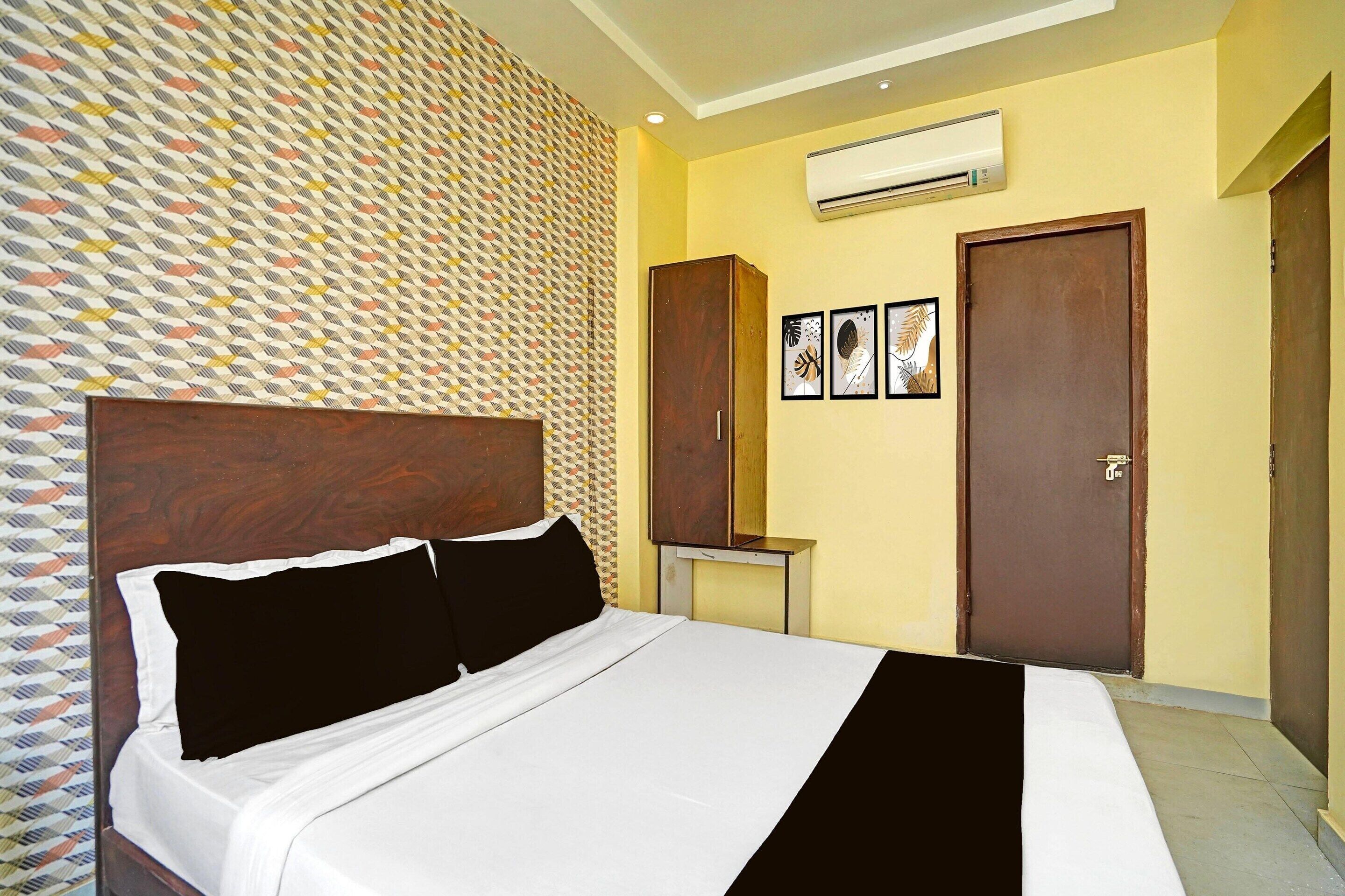 Een hotelkamer met een bed, kledingkast en een airconditioning.