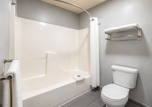 Un baño con bañera, inodoro y un perchero para toallas.