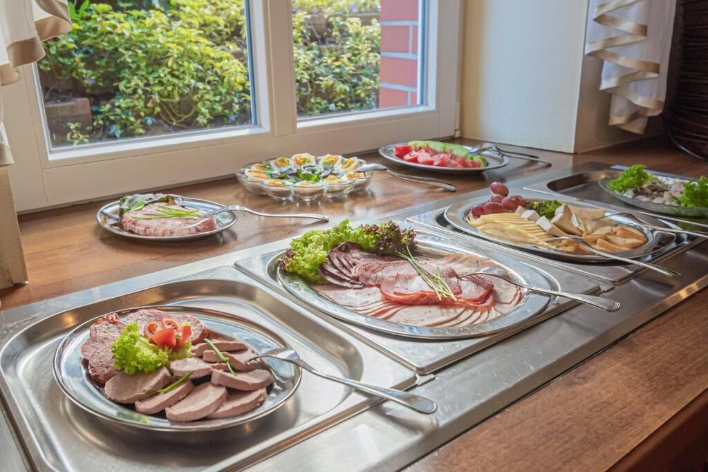 A buffet with various food items and a window view.