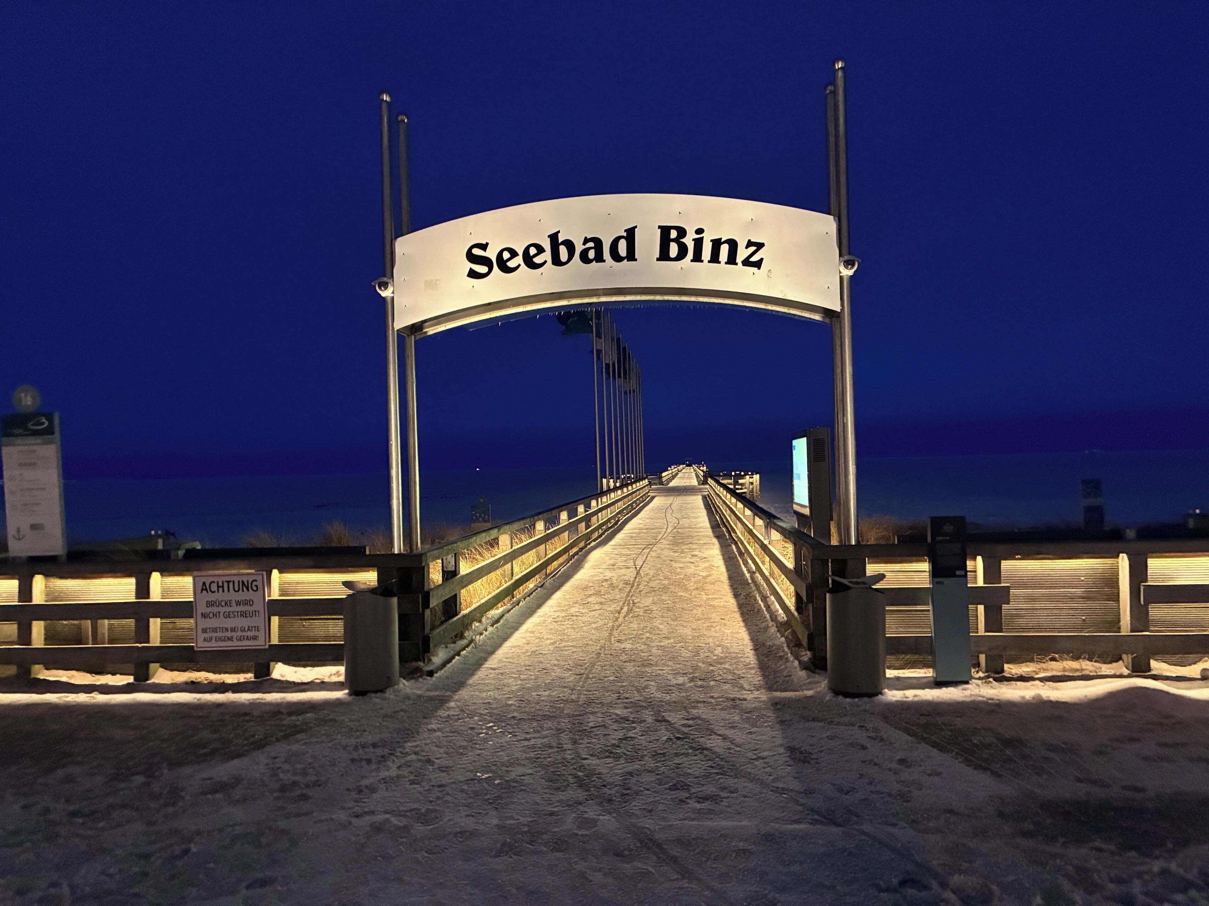 A bridge entrance with a sign reading 'Seebad Binz' and a warning sign about parking.