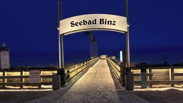 Een toegang tot een brug, met een bord waarop 'Seebad Binz' staat en een waarschuwingsbord over parkeren.