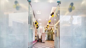 A hallway with glass doors, a checkered floor, and a green carpet.