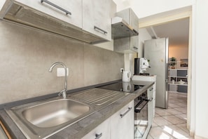 Una cocina moderna con un lavaplatos de acero inoxidable, un horno empotrado y un refrigerador.