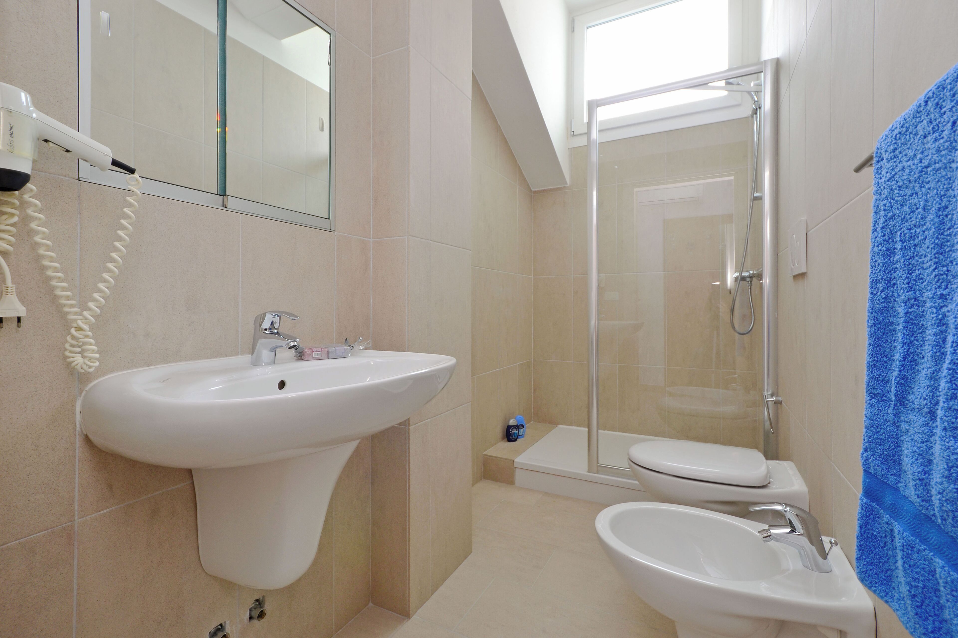 Une salle de bain équipée d’un lavabo, d’un bidet, de toilettes et d’une douche à parois de verre.