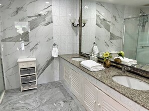 A bathroom with marble walls, two sinks, a vanity, a mirror, and a shower. - 5 Bedrooms Villa 5 min Walk to Bangtao Beach (Si Sunthon)