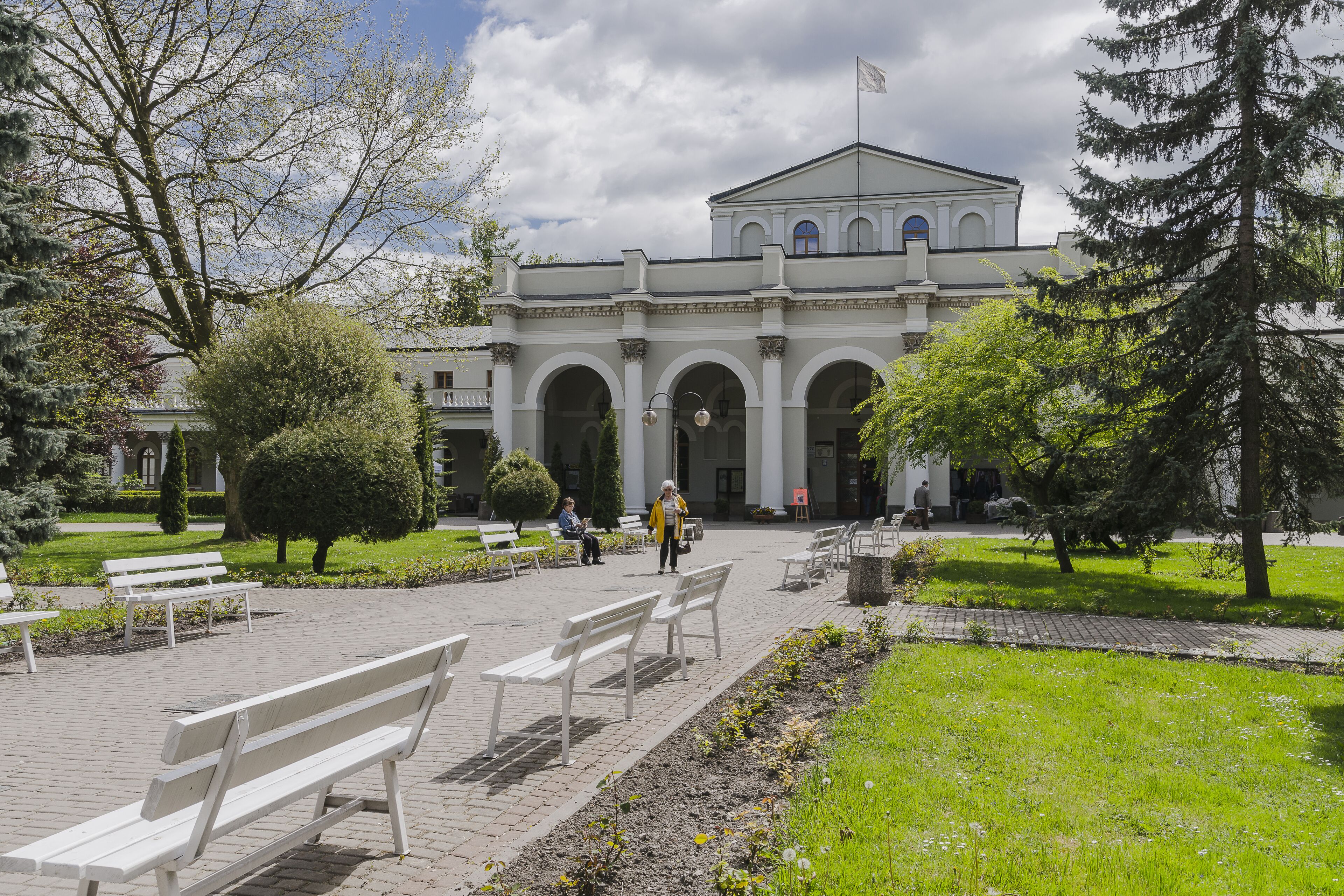 Ein Gebäude im klassischen Stil, mit einem zentralen Giebel und Säulen.