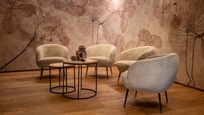 A room with three armchairs, a round table, and a wall with leaf patterns. - Apartment 'Altmessnerhof Glücksklee' with Mountain View, Shared Terrace and Wi-Fi (Dobbiaco)