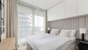 Een moderne hotelkamer met een groot bed, een bureau en uitzicht over de stad.