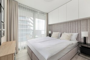 Une chambre d’hôtel moderne avec un grand lit, un bureau et une vue sur la ville.