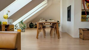 Ein modernes Loft mit Essbereich, einem gelben Tisch und einem Schlafplatz in der Loge.