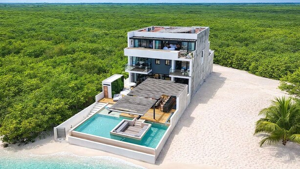 A modern multi-story building with a rooftop pool and a large deck area.