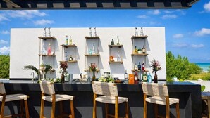 A bar area with wooden chairs and shelves of bottles.