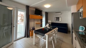 Eine moderne Küche mit Essbereich, integriertem Mikrowellenherd und einer Glastür, die auf einen Balkon führt.