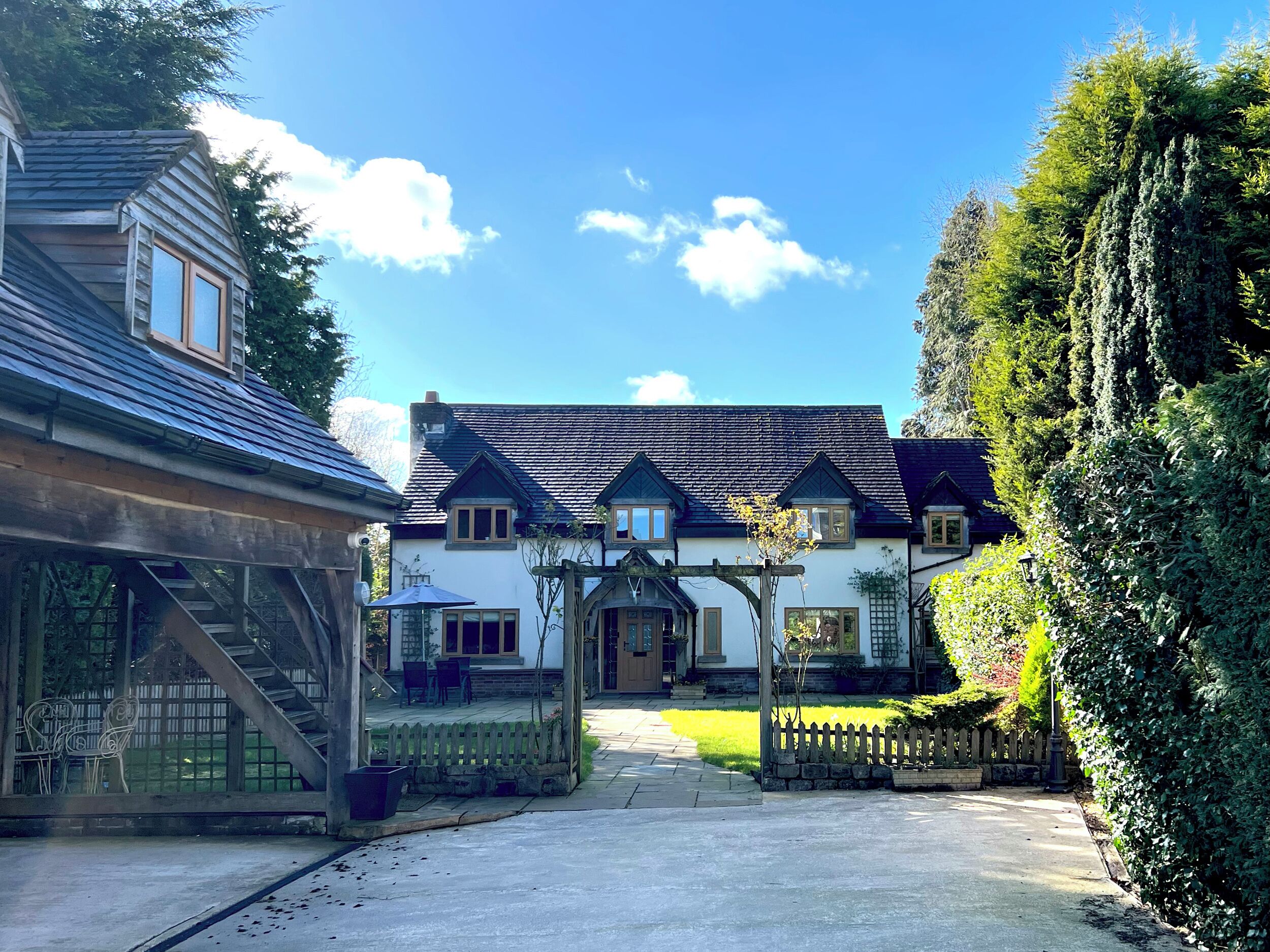 A traditional house with a front porch, a staircase leading to the entrance, and a well-maintained lawn.