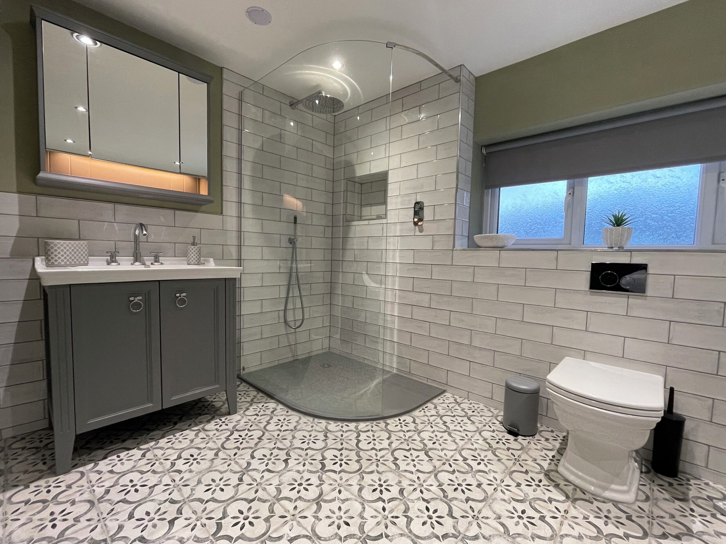 Een moderne badkamer met douche, toilet en wastafel.