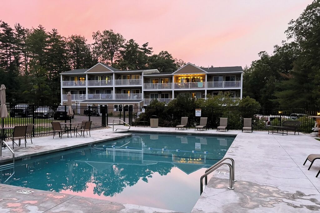 Ein Hotel mit Pool, Außenbereich und einem zweistöckigen Gebäude.