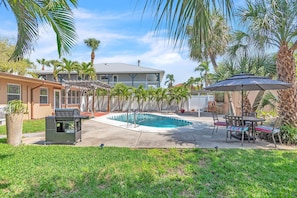 A backyard with a swimming pool, outdoor furniture, and a barbecue grill. - Sunset Dreams (St. Pete Beach)